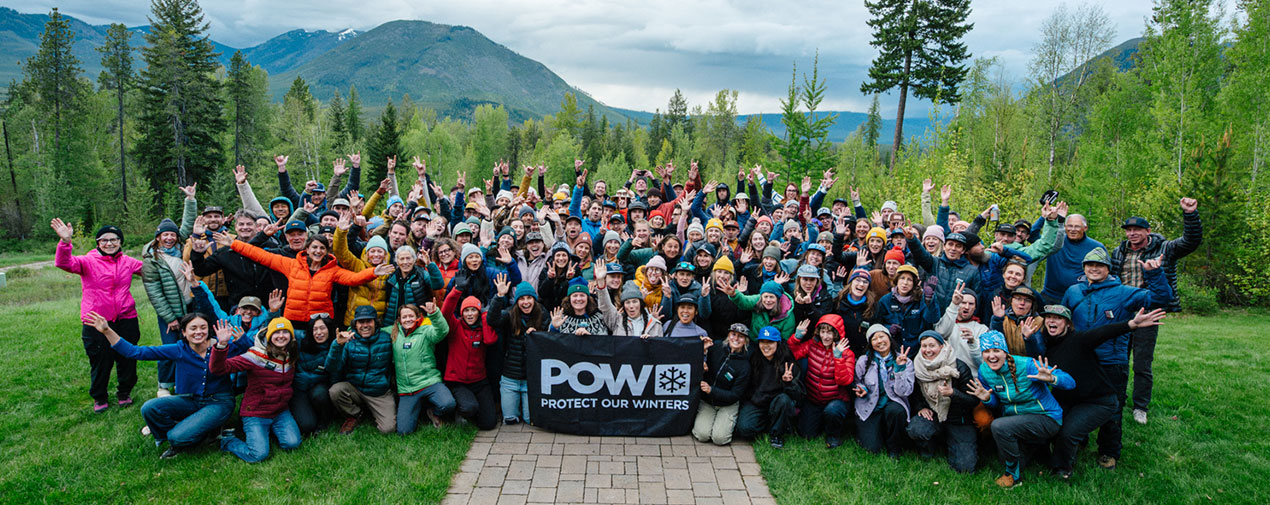 Large group with banner in front of mountains