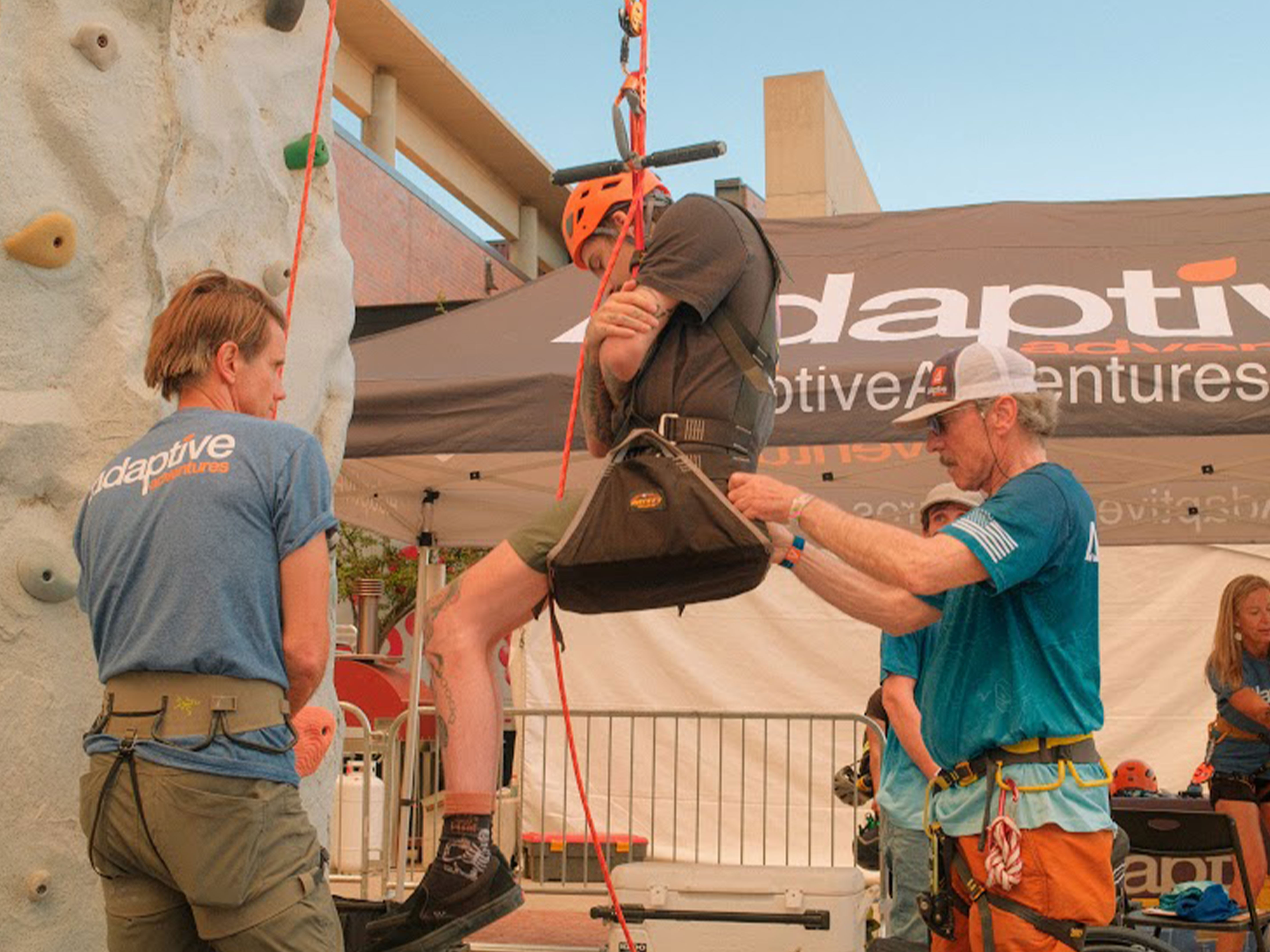 person being lowered off of climbing wall